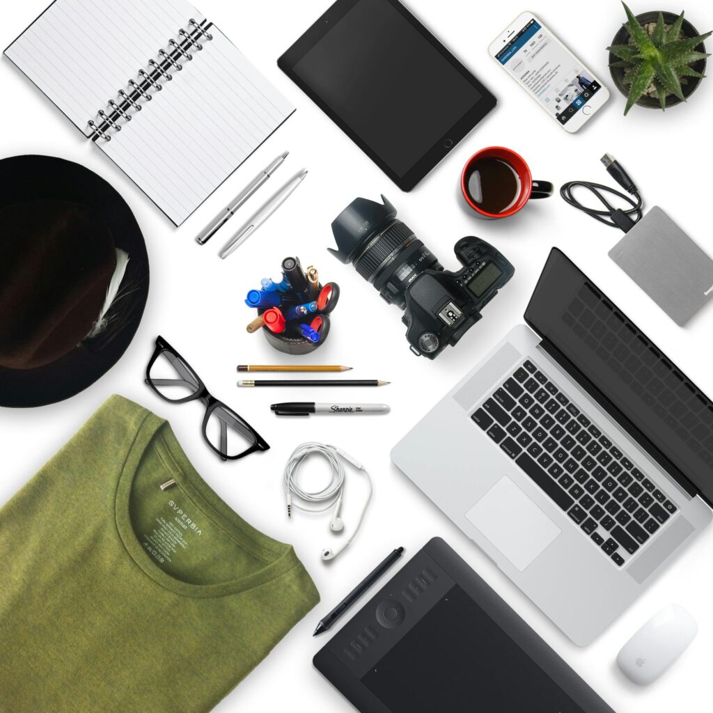 Top view of a creative workspace with camera, laptop, and accessories, perfect for a designer or photographer.